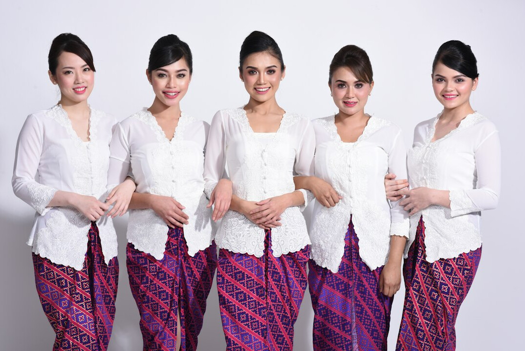 Group of six Malaysian professionals standing together smiling